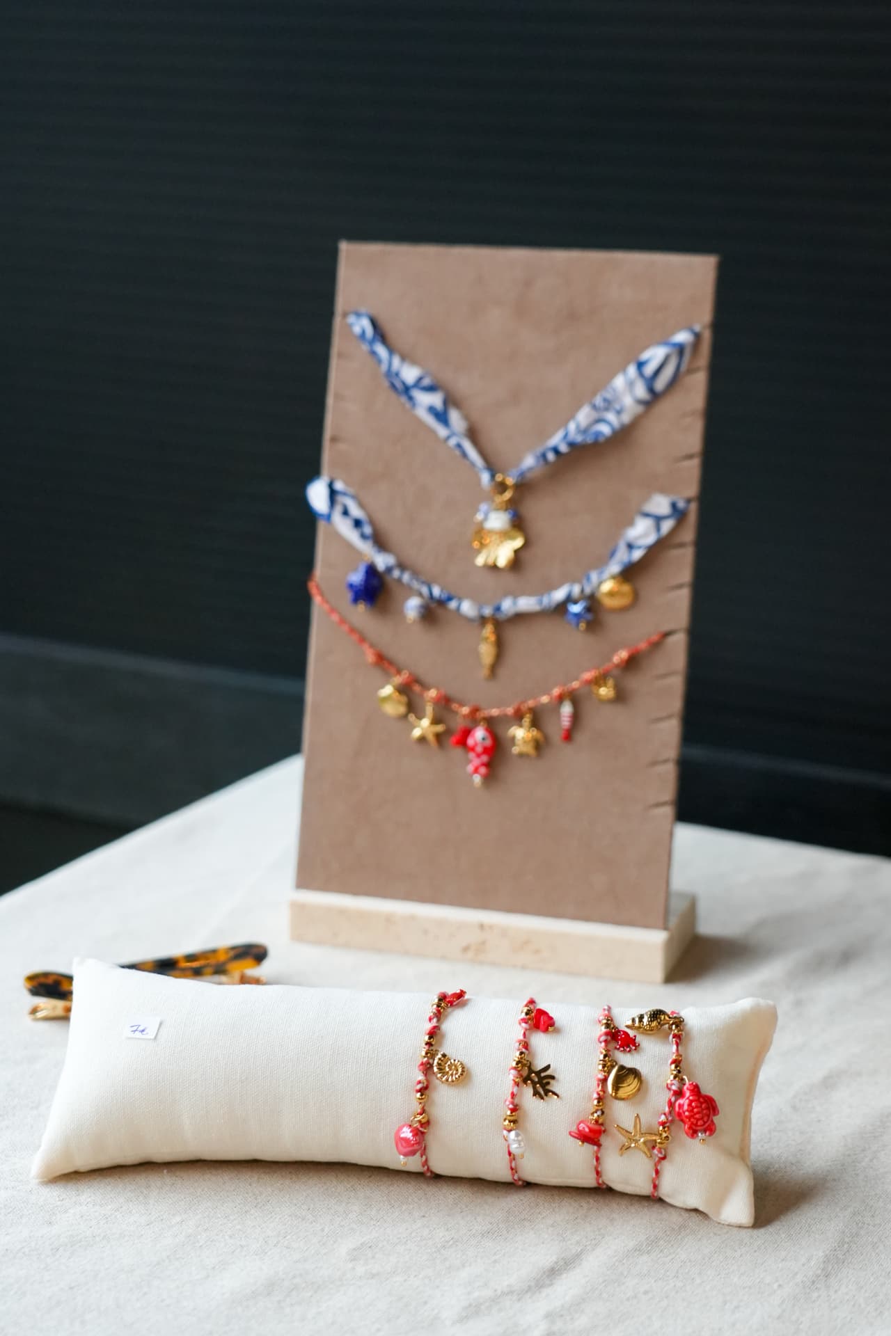 Handgemaakte armbandjes en kettingen op een displaytafel met wit tafelkleed