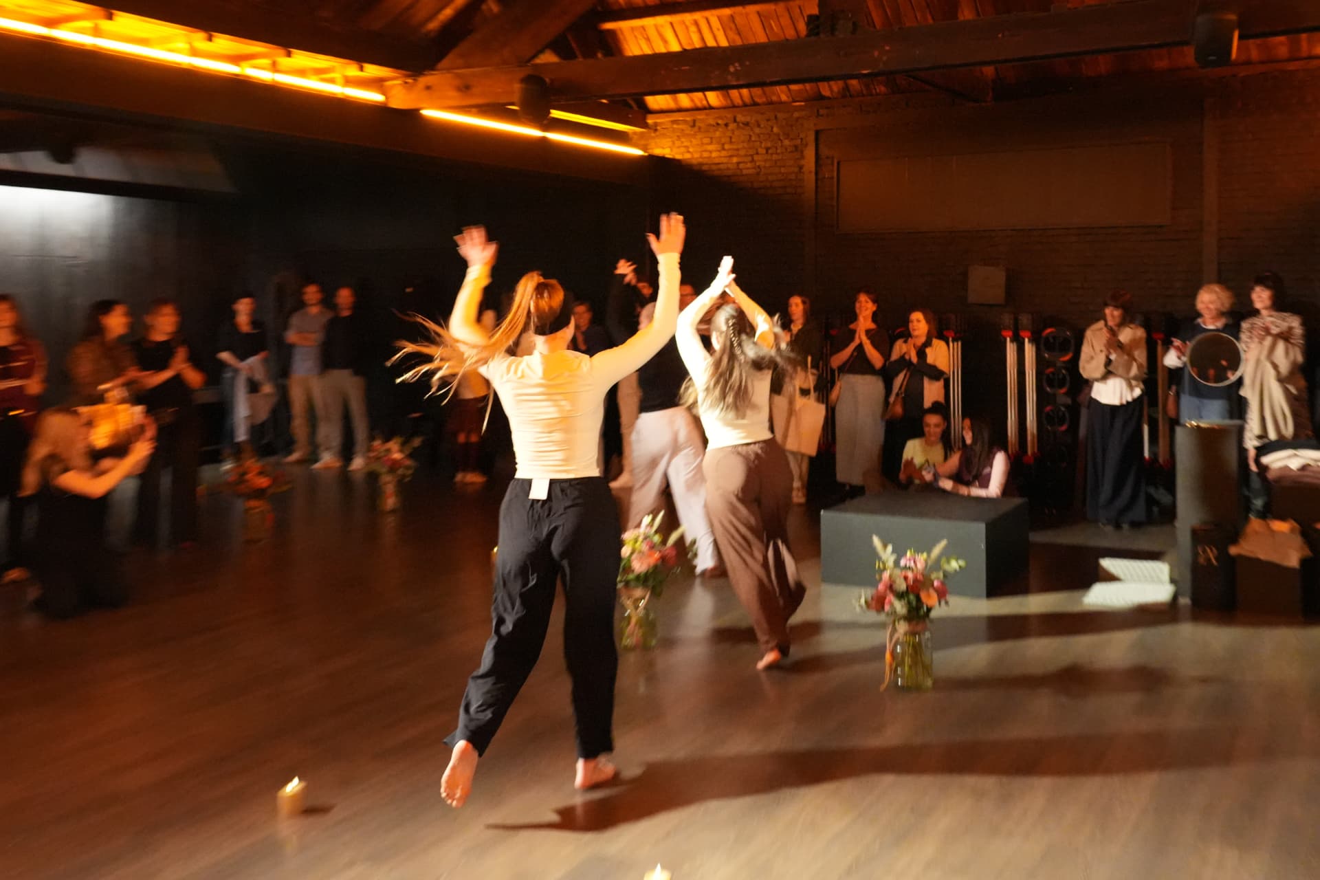 Modellen dansen tussen bloemen en kaarsen voor het applaudisserende publiek