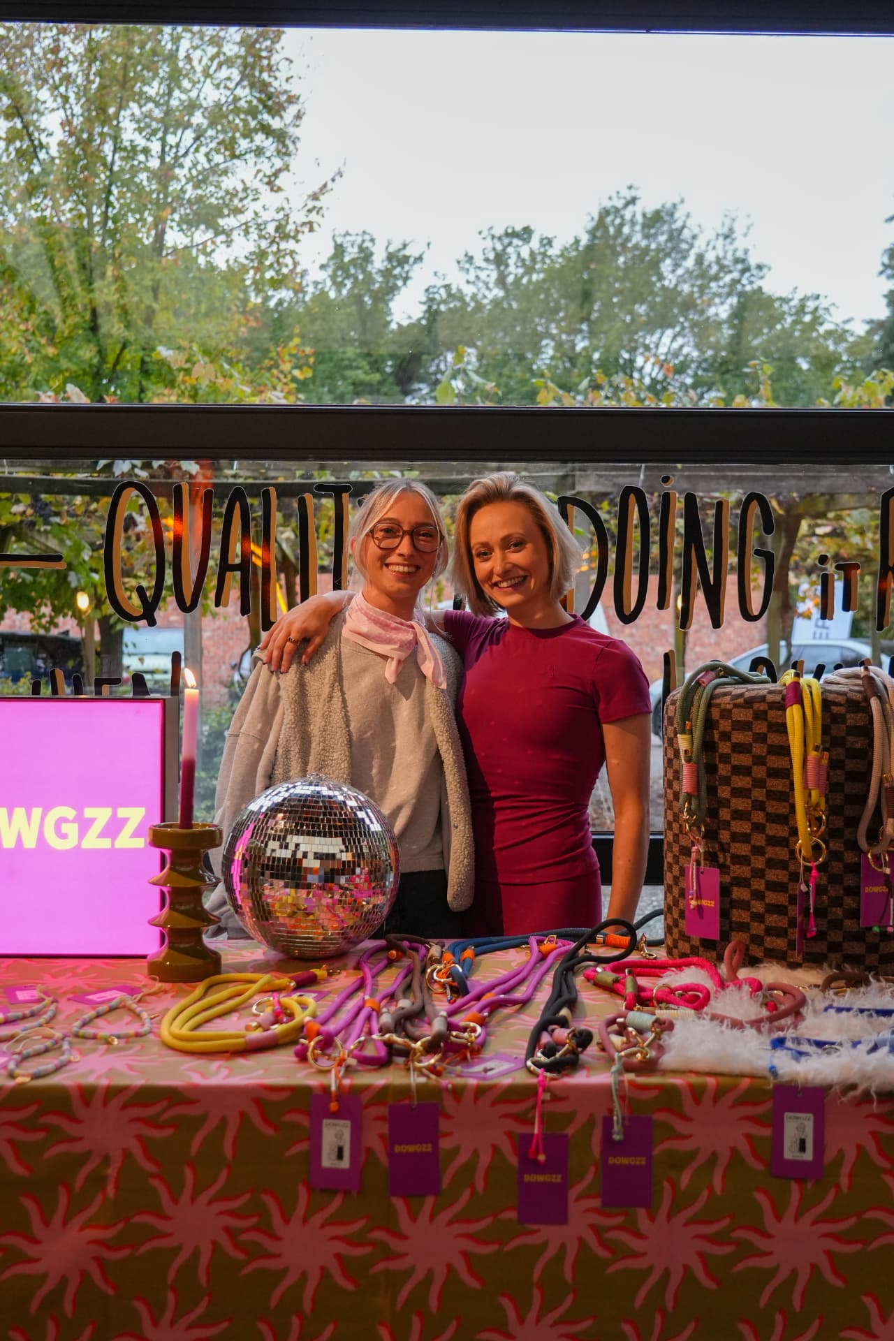 Twee vrouwen poseren achter de kleurrijke hondelijnen van DOWGZZ