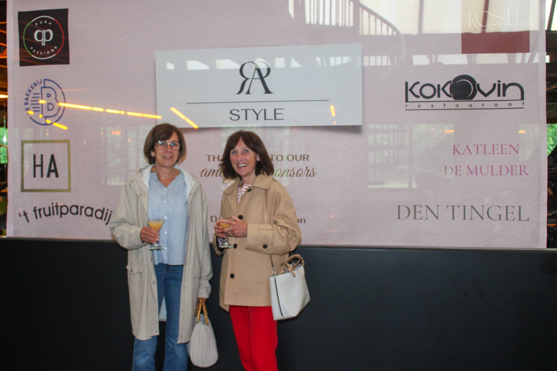 Twee bezoekers met een cocktail voor de RA Style-wand