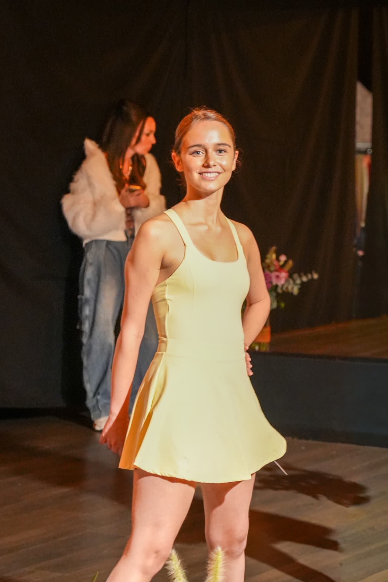 Een model poseert in een gele sportjurk