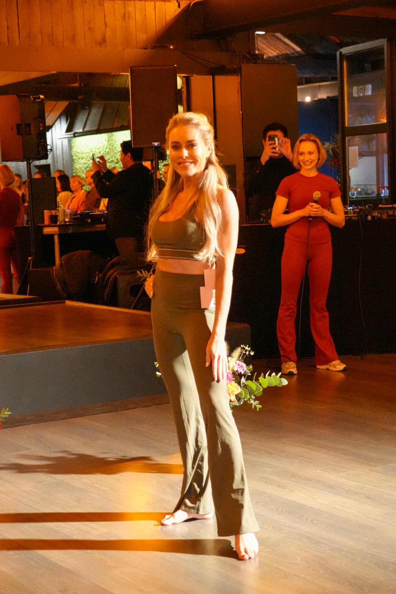 Een model poseert in een groene sporttop en wijde groene broek
