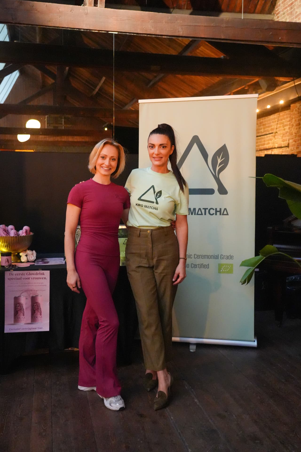 Twee vrouwen in een bordeauxrode en groene outfit voor het Kiro Matcha-doek