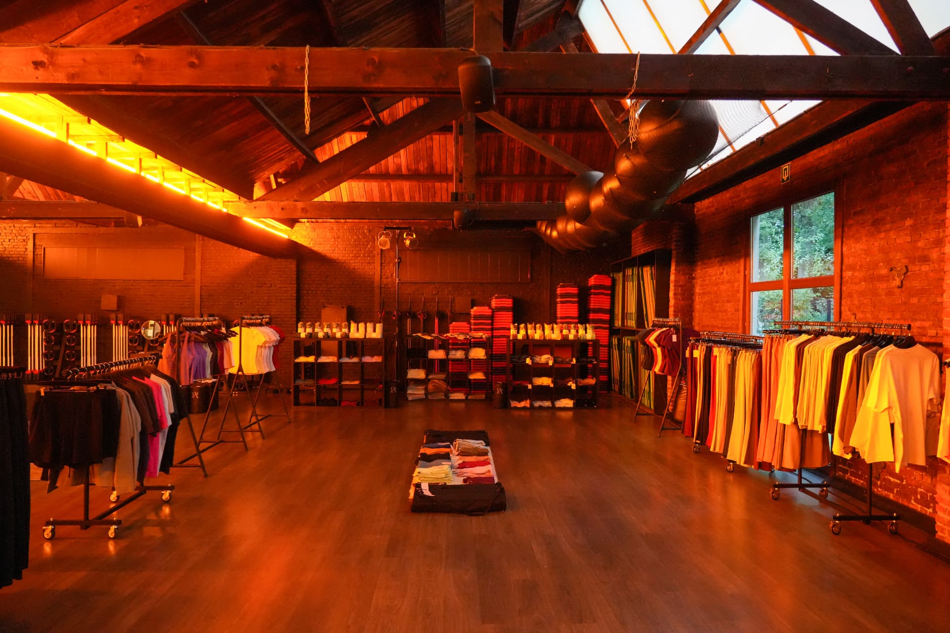 Kledingrekken en opgevouwen kleding in de zaal van Autumn Edit