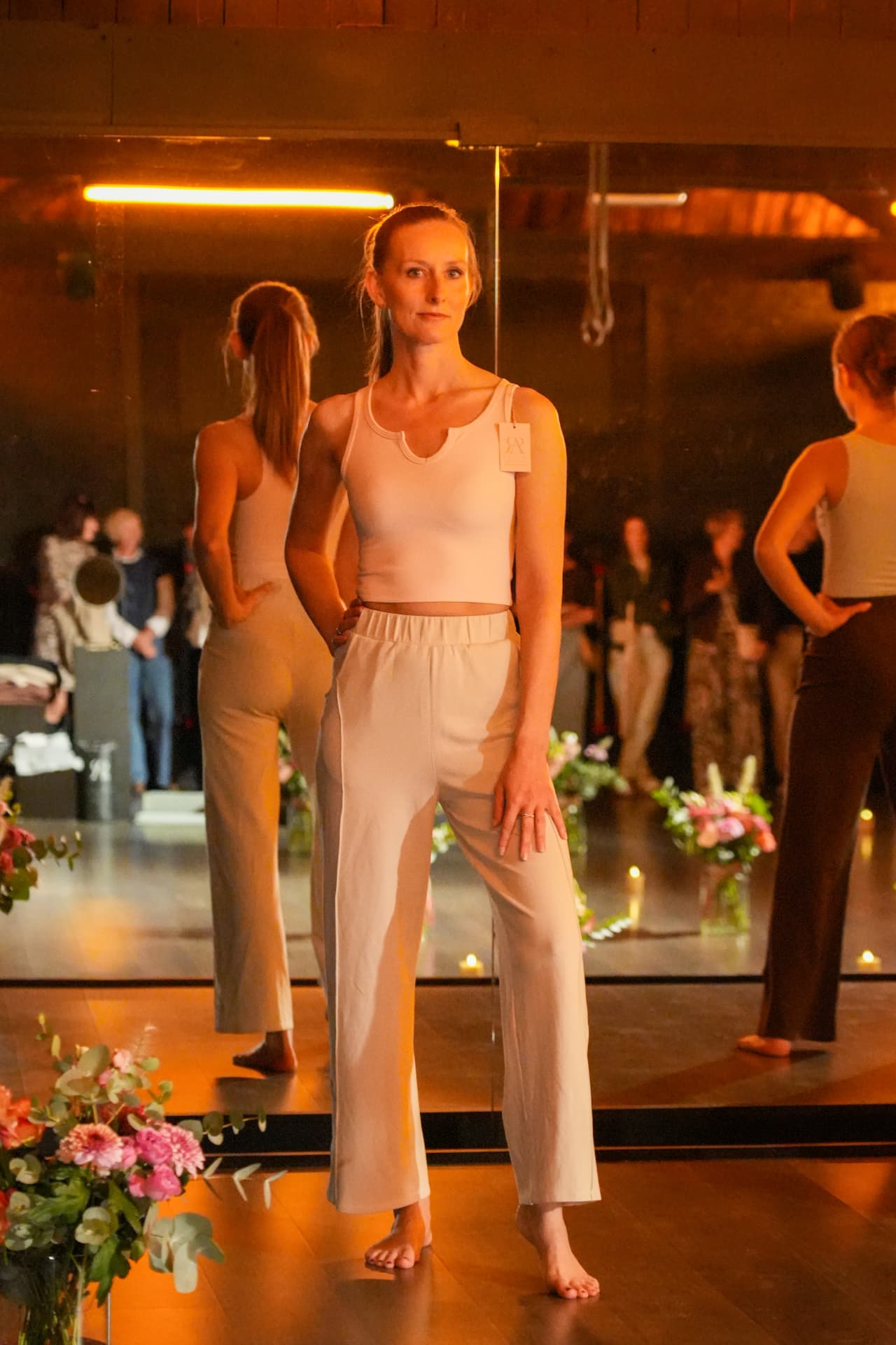 Een model poseert in een witte korte top en wijde witte broek